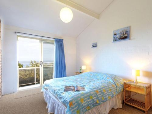 a bedroom with a bed and a large window at Oceanside 04 Sea Bliss in Blueys Beach