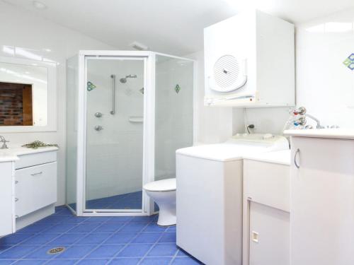 a white bathroom with a shower and a toilet at Oceanside 04 Sea Bliss in Blueys Beach