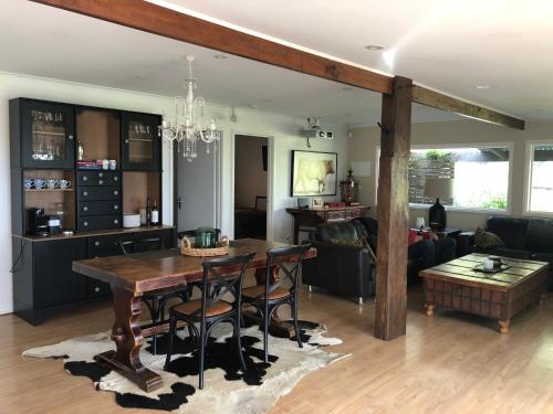 a dining room and living room with a table and chairs at Stylish 2-Bed Home, Stunning View, Fire Pit, Festoon Lights, BBQ and walk to Pub in Poowong