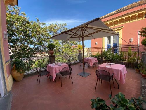 a patio with tables and chairs and an umbrella at The Secret Garden Relais in Piano di Sorrento