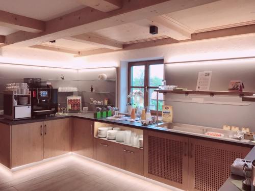 a large kitchen with a counter with a coffee maker at Hotel am Wiesenhang - Garni in Bad Kohlgrub