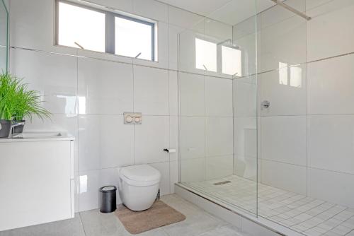 a white bathroom with a shower and a toilet at Sea De La Vie 25 by Host Agents in La Mercy