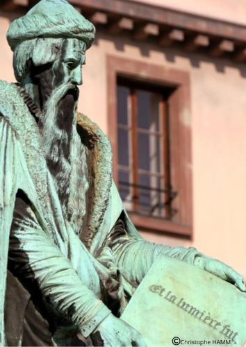 a statue of a man holding a sign at Hotel Suisse in Strasbourg