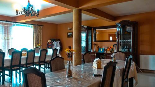 a dining room with a long table and chairs at Acasa in Maramures in Fereşti