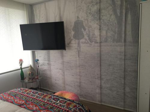 ein Wohnzimmer mit einem TV an der Wand in der Unterkunft Bogota Calle 105 Norte - Loft Entero in Bogotá