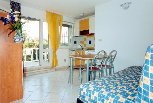 a bedroom with a table and chairs and a kitchen at Appartamenti Doria II in Porto Garibaldi