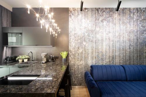 a kitchen with a counter and a blue couch at Jacuzzi Apartment Main Square in Kraków