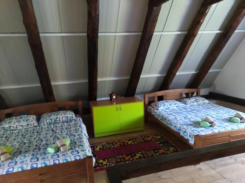 a bedroom with two beds and a green cabinet at Suri in Pluzine
