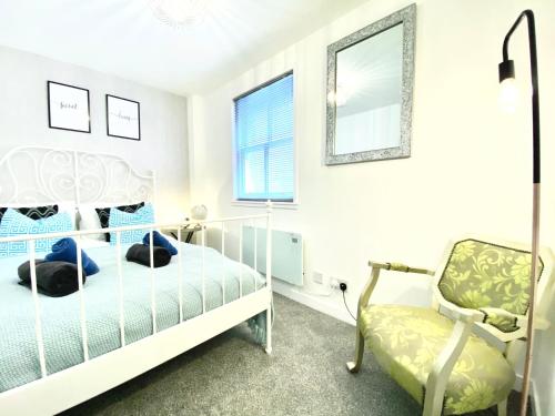 a bedroom with a bed and a chair at Stylish Central 2 Bedroom Apartment - Free Parking, Free WiFi in Orkney
