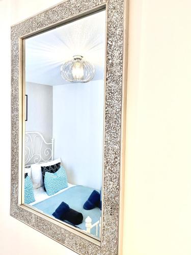 a mirror hanging on a wall in a bedroom at Stylish Central 2 Bedroom Apartment - Free Parking, Free WiFi in Orkney