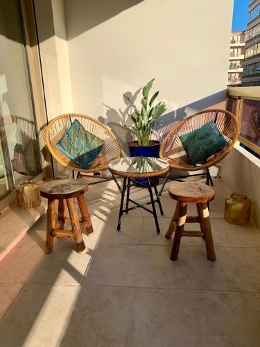 une terrasse avec trois chaises, une table et des bancs dans l'établissement Magnifique 3 pièces en plein cœur de Cannes, à Cannes