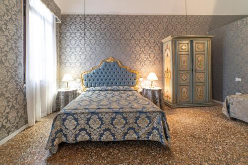 a bedroom with a blue bed and a dresser at palazzo suite ducale in Venice