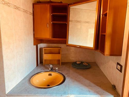 コルニリアにあるCasa Battiのバスルーム(オレンジのシンク、キャビネット付)
