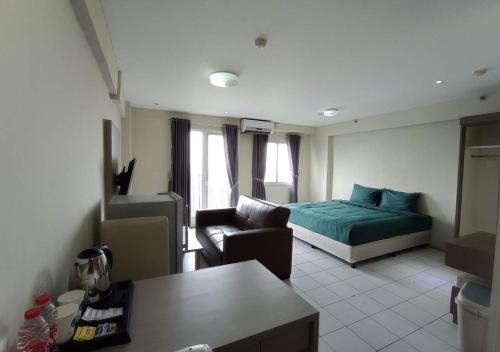 a living room with a bed and a couch at X-pressbedroom Mutiara-Bekasi in Bekasi
