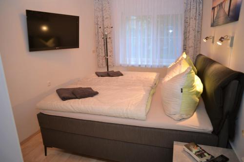 a bedroom with a bed with a television on the wall at Ferienwohnung Koppi in Pamhagen