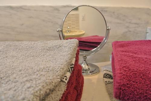 un miroir assis à côté de deux serviettes sur un comptoir dans l'établissement La Casa Tara, à Prades