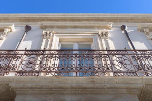 einen Balkon eines Gebäudes mit Fenster in der Unterkunft Sikelia Suites in Noto