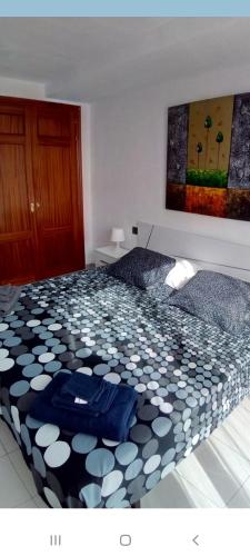 - une chambre avec un lit et une couette noire et blanche dans l'établissement Un dormitorio frente playa El Medano, à El Médano