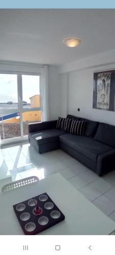 - un salon avec un canapé et une table dans l'établissement Un dormitorio frente playa El Medano, à El Médano