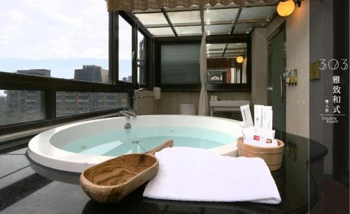 a bath tub in a bathroom with a window at Most Natural Hotel in Jiaoxi