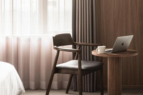 
a desk with a laptop and a chair at Bespoke Hotel Sapporo in Sapporo
