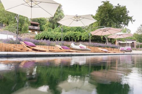 um par de guarda-sóis e cadeiras ao lado de um corpo de água em Drop-Inn Nature, Relax, Hike and SKATE em Ponte da Barca
