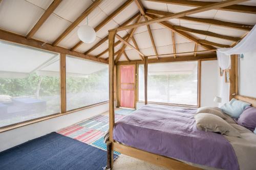 a bedroom with a bed in a room with windows at Drop-Inn Nature, Relax, Hike and SKATE in Ponte da Barca