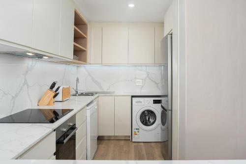 a white kitchen with a washing machine in it at Dolphin Beach E30 in Cape Town