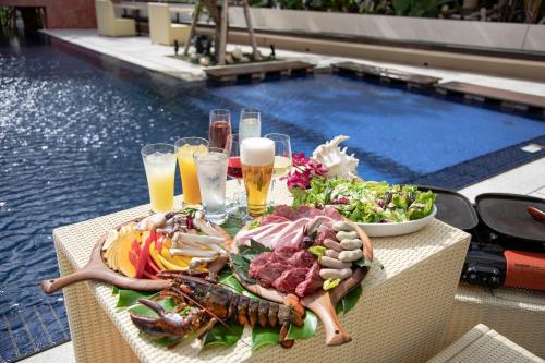a table topped with food and drinks next to a pool at Hotel Palm Royal Resort Kokusai Street in Naha
