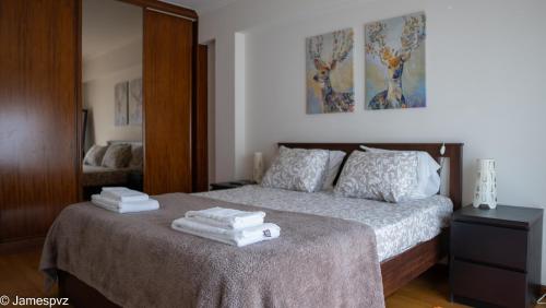 a bedroom with a bed with towels on it at Apartamento Santos Graça in Póvoa de Varzim