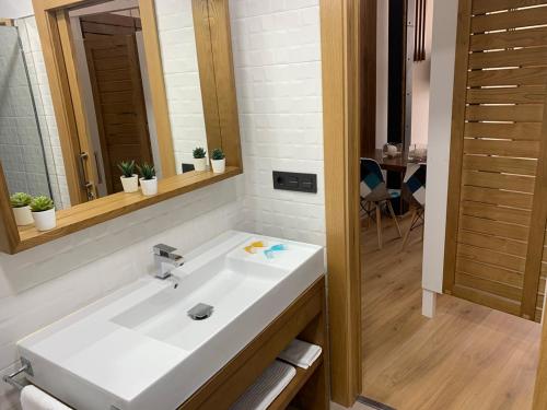 a bathroom with a white sink and a mirror at Apartamentos Plaza Mayor Zamora in Zamora