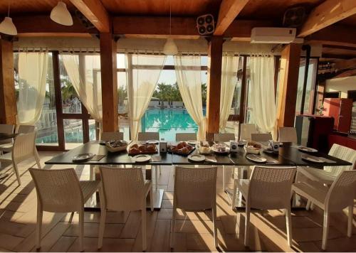 una sala da pranzo con tavolo in vetro e sedie di Residence Parco del Sole a Rodi Garganico