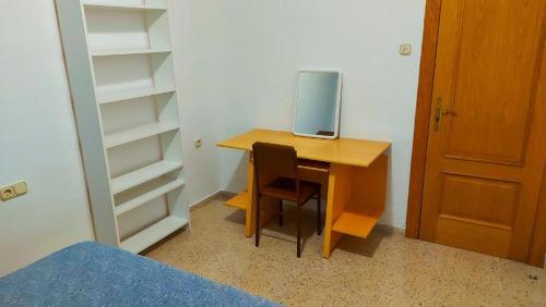 un escritorio con un ordenador junto a un armario en Room in an apartment en Granada