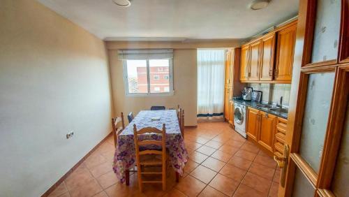 cocina con mesa con sillas y ventana en Room in an apartment en Granada