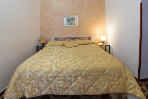 una camera con letto e copriletto dorati di Il giardinetto Lipari centro a Città di Lipari