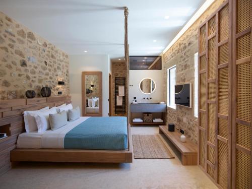 una camera con letto blu e parete in pietra di Riglia Residence a Riglia