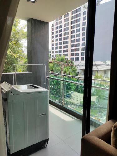 a balcony with a trash can in front of a window at Avatar Suites Hotel - SHA Extra Plus in Bangkok