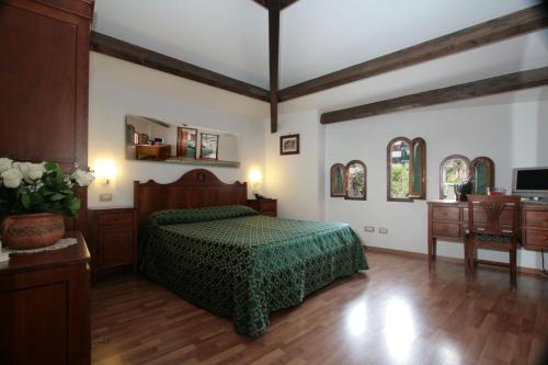sypialnia z łóżkiem z zieloną narzutą w obiekcie La Magnolia Sorrento - City Centre Hotel w Sorrento