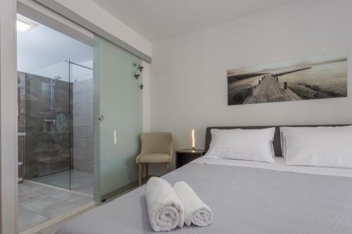 a bedroom with a bed and a glass shower at Guest house Kokolo in Hvar