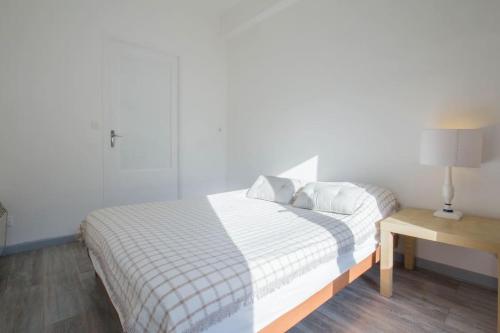 une chambre avec un lit et une table avec une lampe dans l'établissement Balcony on the true Marseille, à Marseille