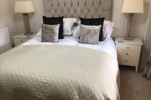 a bedroom with a large white bed with two night stands at Barton Cottage in Bridgwater