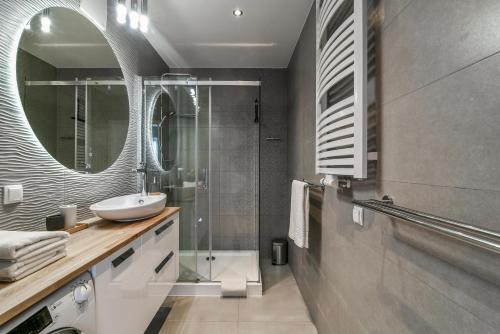 y baño con lavabo y ducha con espejo. en LTC-Apartments Portova, en Gdynia