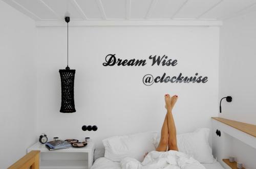 a person laying on a bed in a bedroom with a dream was achieved at Clock Wise Syros in Ermoupoli