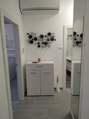 a white kitchen with a sink and a mirror at Apartmani Cobanov Josipa in Grebaštica