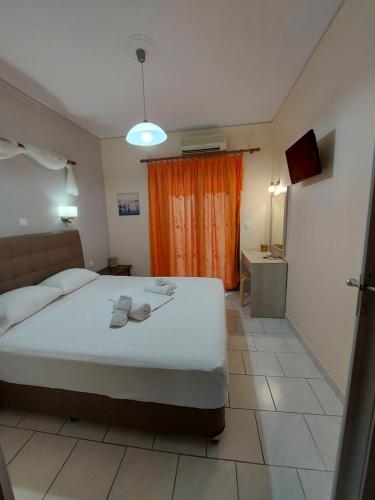 a bedroom with a large bed and a orange curtain at Mavra Studios in Lygia