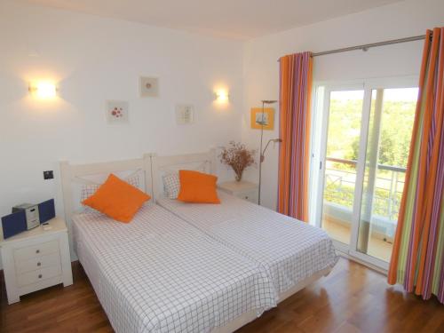 a bedroom with a bed with orange pillows on it at Apartamento Phillipe in Odiáxere