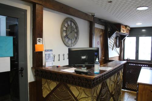 a large clock on a wall above a counter at Hotel Avanti in Pas de la Casa