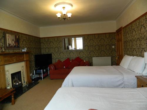 una camera d'albergo con due letti e un camino di Sunnyside House a Rothesay