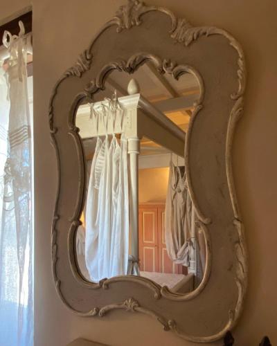 an ornate mirror on a wall in a bedroom at La Magione dei Todaro in Borgo a Buggiano