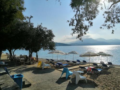 a group of chairs and umbrellas on a beach at Mavra Studios in Lygia